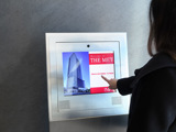 Image of a lady with a finger on a touchscreen video intercom
