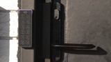 ICT keypad reader next to a black door handle