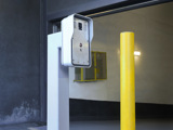 Image of a grey intercom at the entrance to a parking garage