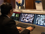 Image of a concierge sitting behind a desk watching security screens