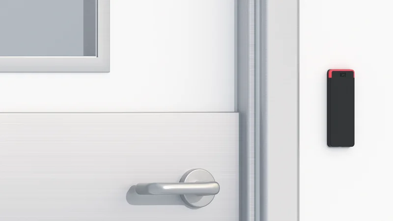 Close-up of an ICT card reader mounted on the wall beside a secured school door