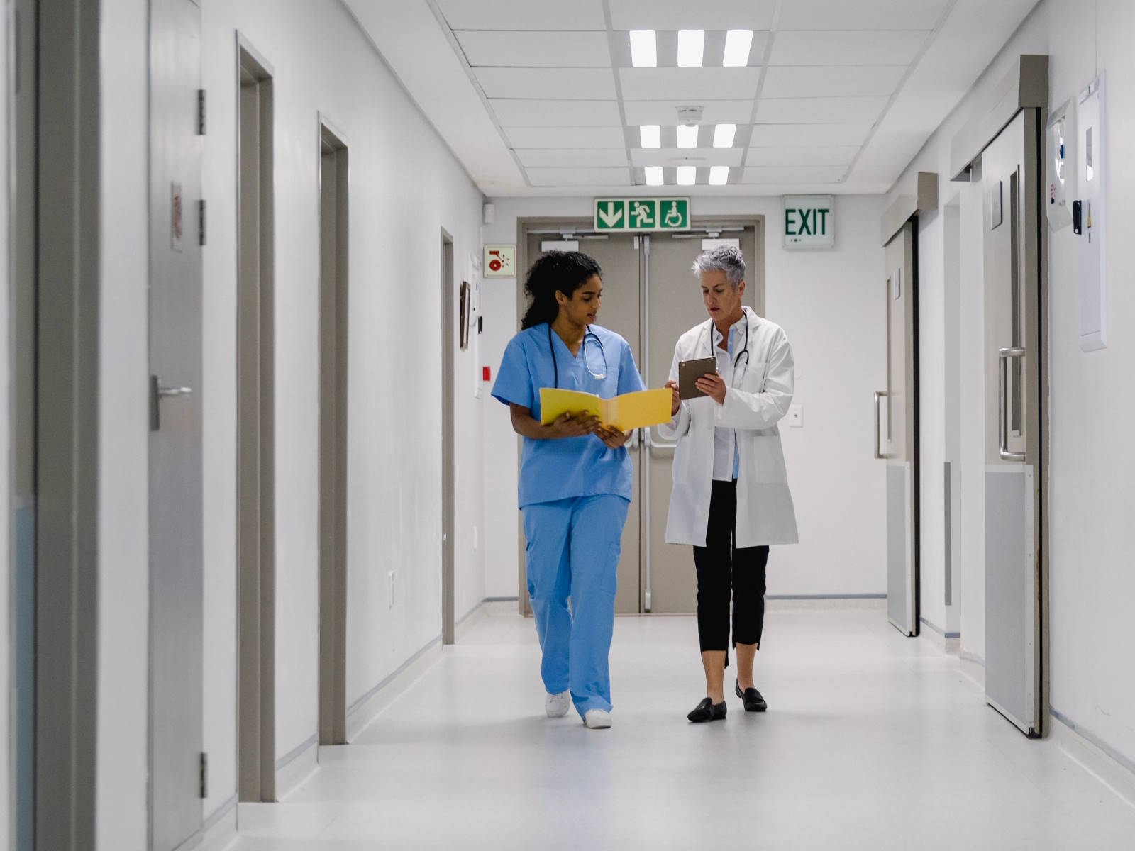 a nurse and a doctor walking through a hospital corridor