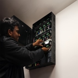 Smiling technician installing equipment in access control panel