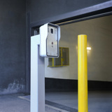 Image of a grey intercom at the entrance to a parking garage