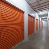 internal view of self storage facility with multiple orange roller doors