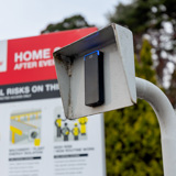 Access reader on pole with sign in background